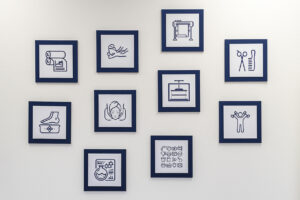 Eine Wand mit neun gerahmten Icons in Blau und Weiß, die verschiedene Dienstleistungen darstellen, darunter Fußpflege, Gesichtspflege, Textildruck und Friseur. Geeignet für Blogbeiträge über Wellness oder Dienstleistungen.